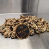 Dried magic mushrooms with "Grown with Love" badge on metallic surface.